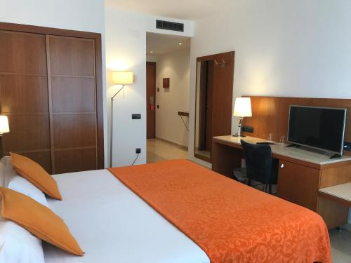 a hotel room with a bed and a desk with a computer at Hotel Calasanz in Molins de Rei