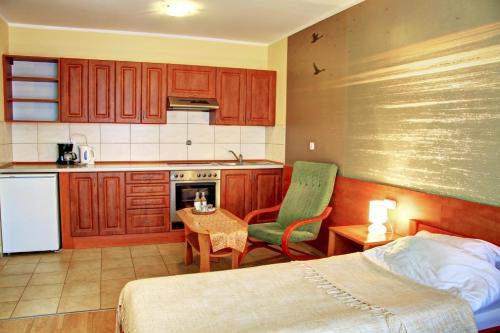 - une cuisine avec un lit et une table dans une chambre dans l'établissement Apartamenty & Restauracja Janus, à Ełk