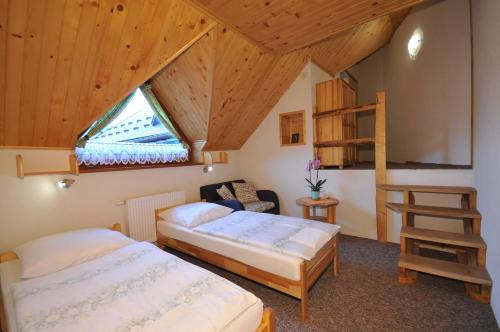 a bedroom with two beds and a loft at Ubytovanie Sokolica in Červený Kláštor