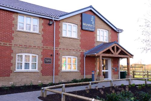 a red brick building with a sign on it at Woodcocks, Lincoln by Marston's Inns in Lincoln