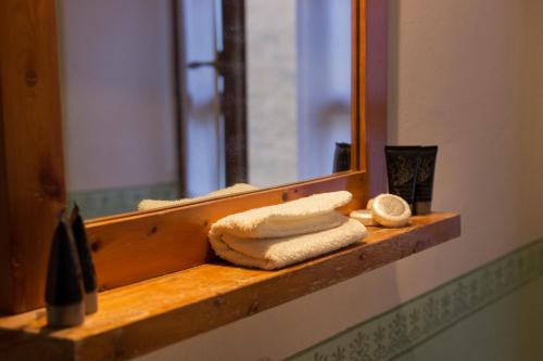a bathroom with a mirror and towels on a shelf at Castello di Grillano Guest House in Ovada