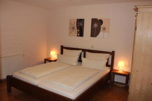ルストにあるGästehaus Krilのベッドルーム1室(ベッド1台、テーブルにランプ2つ付)