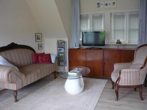 ein Wohnzimmer mit Couch und Fernseher in der Unterkunft Ferienwohnung Ausacker - klein, aber fein! in Ausacker