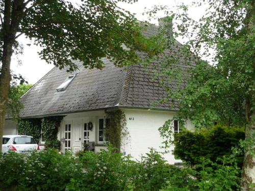 a white house with a shingled roof at Ferienwohnung Doelling in Ausacker