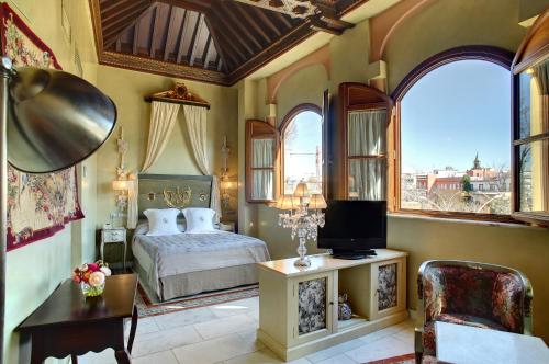 sypialnia z łóżkiem i telewizorem w pokoju w obiekcie Sacristia de Santa Ana w Sewilli