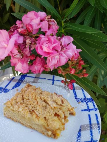 a piece of cake on a plate next to pink flowers at Hotel George in Limenas