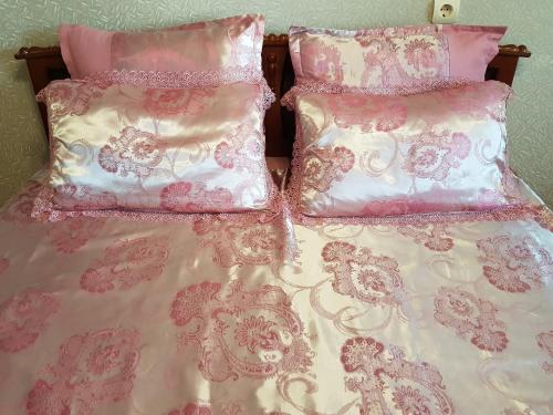 スタールイ・オスコルにあるОднокомнатная квартира на Восточномのベッド2台(ピンクと白のシーツ、枕付)