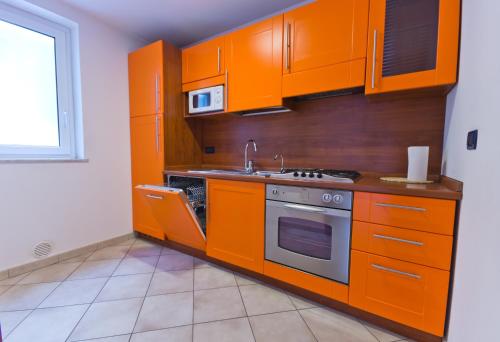 kuchnia z pomarańczowymi szafkami i kuchenką w obiekcie Palazzo Gallo w mieście Palermo