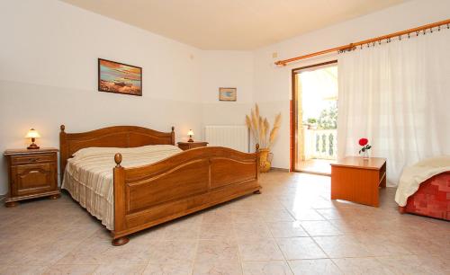 een slaapkamer met een houten bed en een groot raam bij Apartments Lili in Medulin