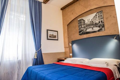 a bedroom with a blue and red bed and a window at San Peter Rome B&B in Rome