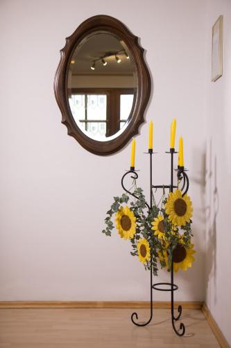 a vase of sunflowers in front of a mirror at Ferienwohnung Am Sonnenhang in Neualbenreuth