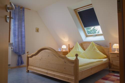 una camera con letto in legno e cuscini gialli di Ferienwohnung Am Sonnenhang a Neualbenreuth