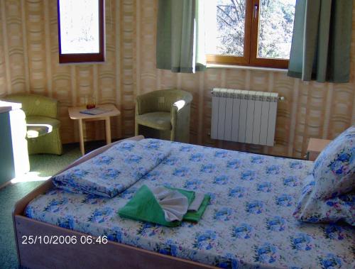 a bedroom with a bed with a blue comforter at Family Hotel Emaly 1 in Bankya