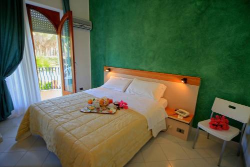 a bedroom with a bed with a tray of fruit on it at Hotel Orsa Maggiore in Vulcano