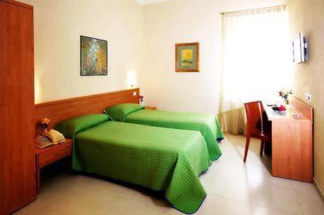 a bedroom with two green beds and a table at Borgo San Martino in Bra