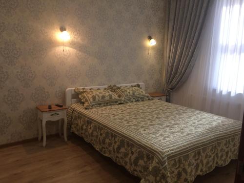 a bedroom with a bed and two lights on the wall at Morskaya zhemchuzhina na Marselskoy in Kryzhanivka