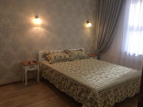 クリーズハニュカにあるMorskaya zhemchuzhina na Marselskoyのベッドルーム1室(ベッド1台、壁に照明2つ付)