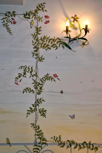 a painting of a plant with flowers and butterflies at Hotel San Luca in Spoleto