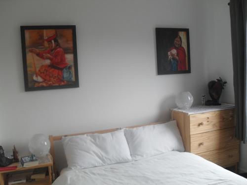 エディンバラにあるEdinburgh Duplex Apartmentのベッドルーム1室(ベッド1台付)が備わります。壁には絵画が飾られています。