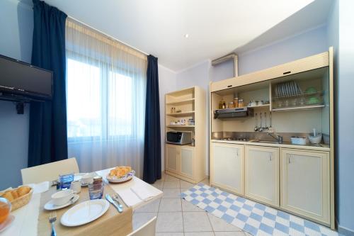 a kitchen with a table and a dining room at Hotel Sirio in Lido di Camaiore
