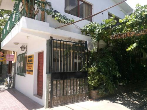a white building with a black gate on a street at Residencial Shalom in Cafayate