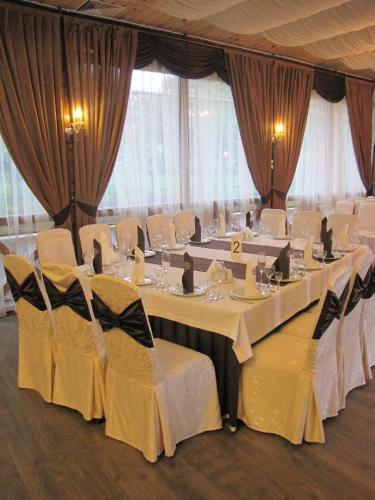 a conference room with white tables and white chairs at VVP Club Hotel in Tiraspol