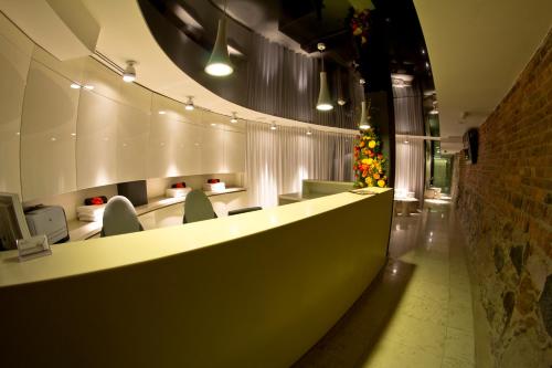 a lobby with a long counter with chairs and lights at Hotel Bulwar in Toruń
