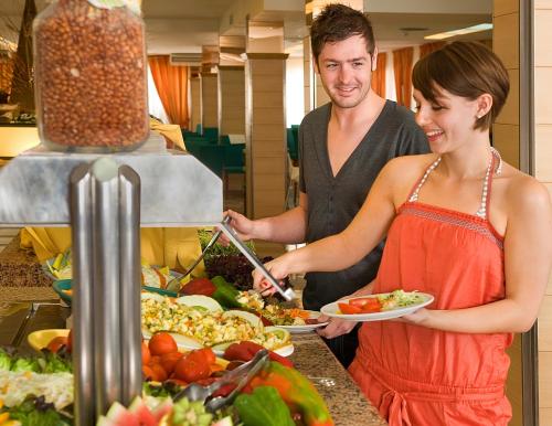 een man en een vrouw met een bord eten bij HSM Calas Park in Calas de Mallorca