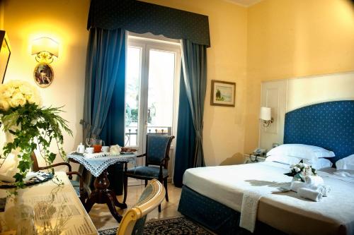 a bedroom with a bed and a table and a window at Villaggio San Giovanni in San Giorgio Ionico