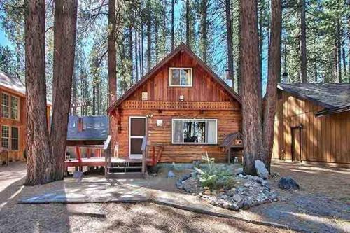 uma cabana de madeira na floresta com árvores em Hank Monk Chalet em South Lake Tahoe