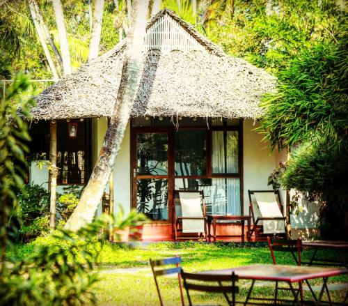 a house with chairs and a table in front of it at Les 3 Elephants in Cherai Beach