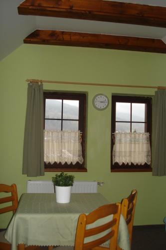 a dining room with a table and two windows at Penzion Seidl in Rokytnice nad Jizerou