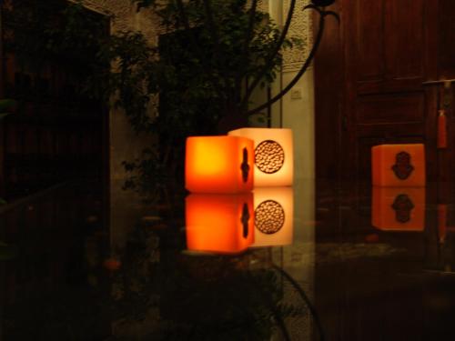 two orange lights on a wall with a door at Riad Les Nuits de Marrakech in Marrakech