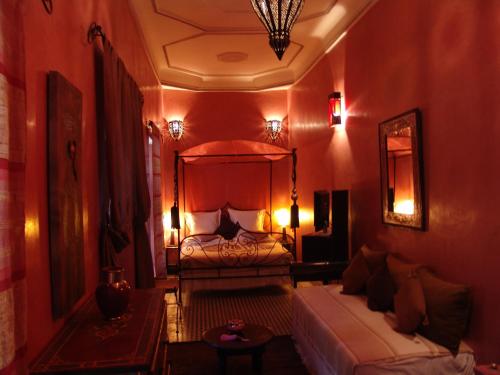 a living room with a bed and a couch at Riad Les Nuits de Marrakech in Marrakech