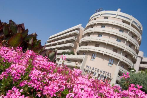 a building with pink flowers in front of it at Hotel Palace in Senigallia