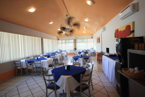 een restaurant met tafels en stoelen en een plafondventilator bij Hotel Splash Inn in Silao