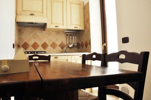 a kitchen with a wooden table with chairs and cabinets at Al Borgo Antico Ristorante e B&B in Crispiano