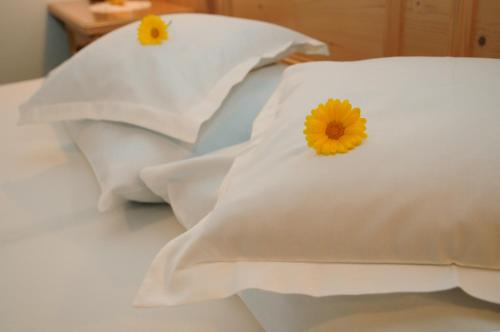 a white bedspread with flowers on top of it at Hotel Kirchenwirt in Dobbiaco
