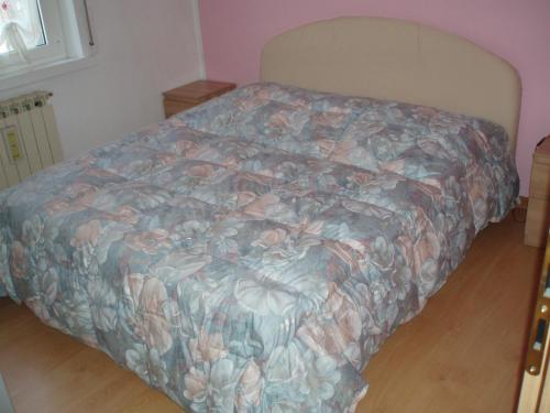 1 Schlafzimmer mit einem Bett mit Blumendecke in der Unterkunft Ai Tre Fichi in Cedas