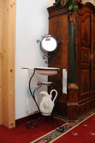 a mirror sitting on a table next to a wall at Hotel Kirchenwirt in Dobbiaco