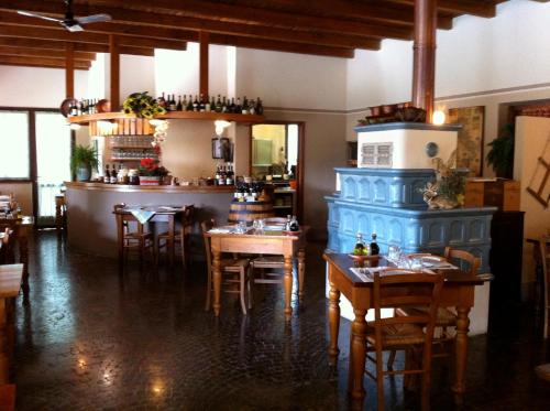 un comedor con mesas y un pilar azul en un restaurante en Agriturismo La Montina, en Ponti Sul Mincio
