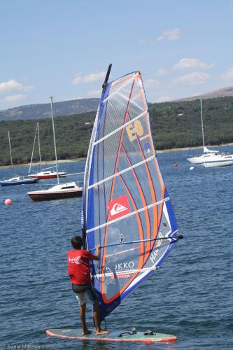 a man standing on a surfboard with a sail at Alojamientos La Dehesa in El Berrueco