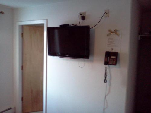 a flat screen tv hanging on a wall with a phone at Borealis Inn in Fairbanks