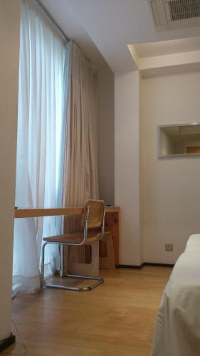 a chair sitting in a room with a window at La Plaza II in Luanco