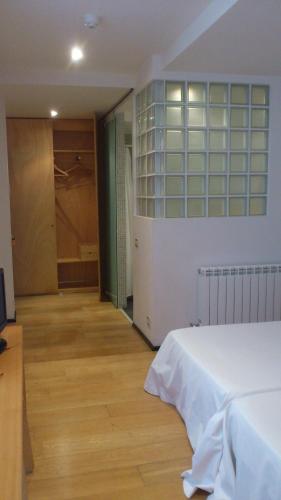 a bedroom with a white bed and a closet at La Plaza II in Luanco