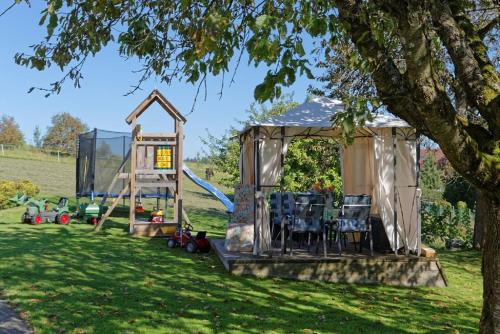 a gazebo with chairs and a playground at Ferienwohnung Familie Resch in Wegscheid