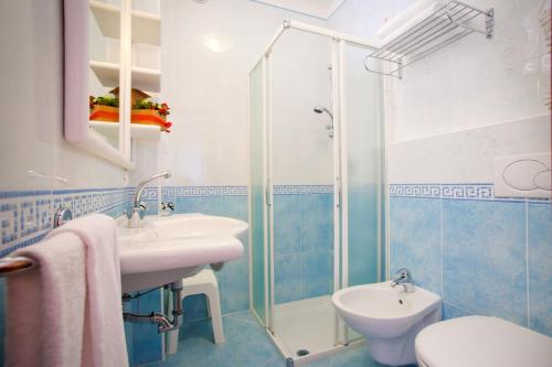 W łazience znajduje się umywalka, toaleta i prysznic. w obiekcie Hotel Alexander w Caorle
