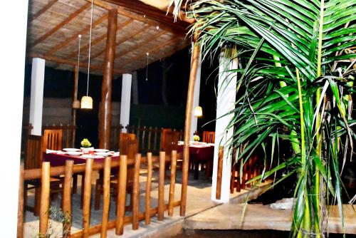a dining room with a table and a plant at Baby Elephant Green House in Udawalawe