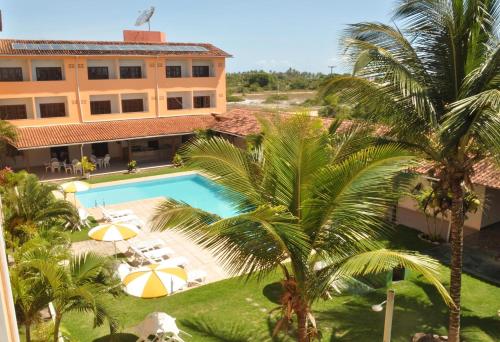 an aerial view of a hotel with a pool and palm trees at Quiriri Park Hotel in Prado