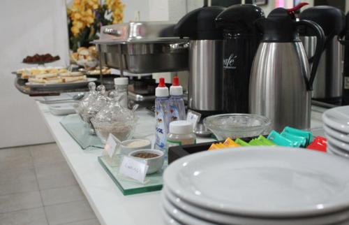 a kitchen counter with plates and utensils at Hotel Express - Leva e busca no aeroporto grátis 24 horas in Várzea Grande